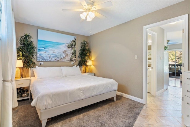 tiled bedroom featuring ceiling fan and ensuite bathroom