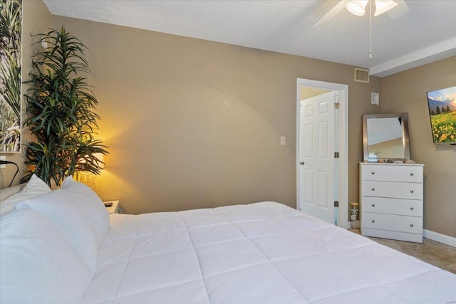 bedroom with carpet, a textured ceiling, and ceiling fan