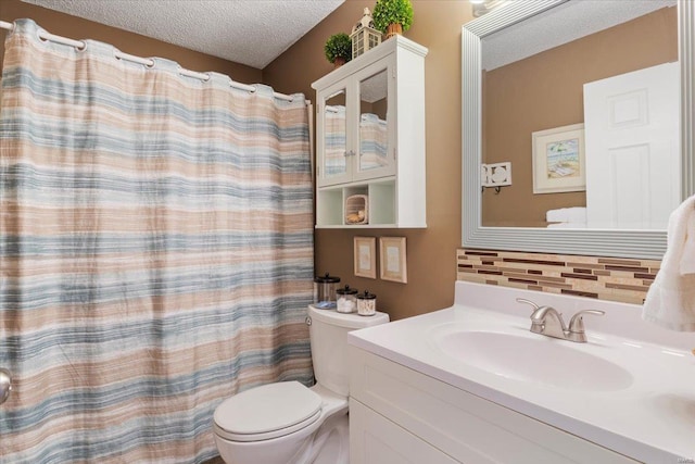 bathroom with vanity, toilet, a textured ceiling, and walk in shower