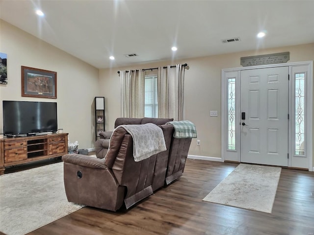 living room with dark hardwood / wood-style flooring, plenty of natural light, and lofted ceiling