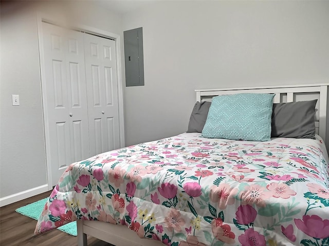 bedroom featuring electric panel, a closet, and dark hardwood / wood-style flooring