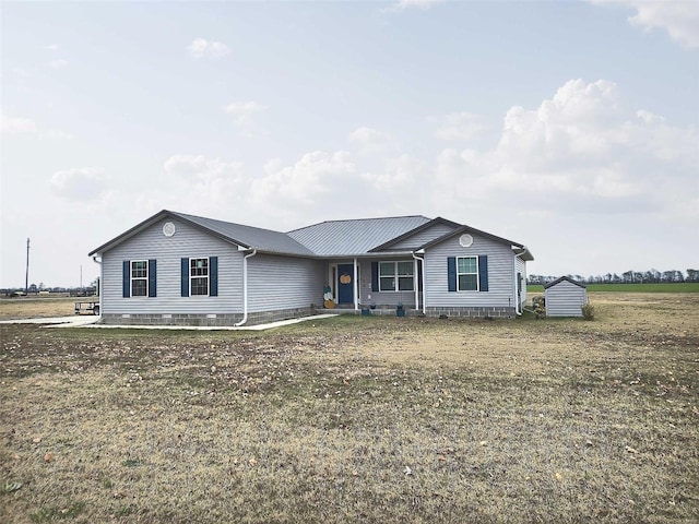 single story home featuring a storage unit and a front lawn