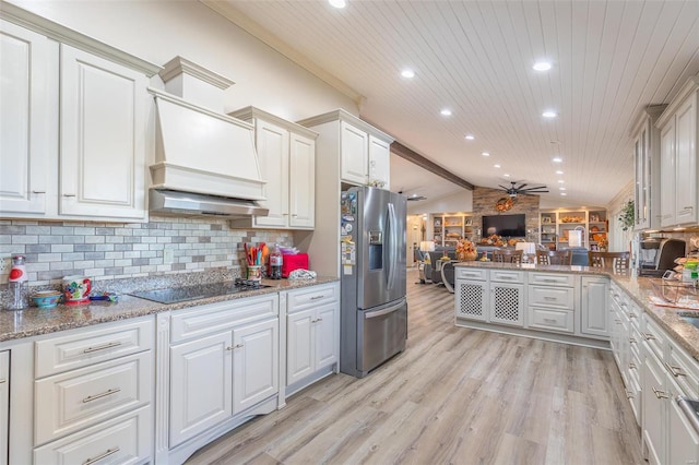 kitchen featuring ceiling fan, vaulted ceiling with beams, stainless steel fridge with ice dispenser, black electric stovetop, and light wood-type flooring