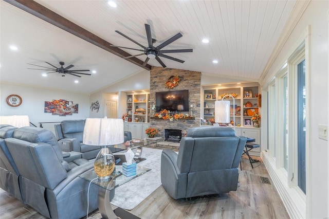 living room featuring ceiling fan, lofted ceiling with beams, light hardwood / wood-style flooring, built in features, and a fireplace