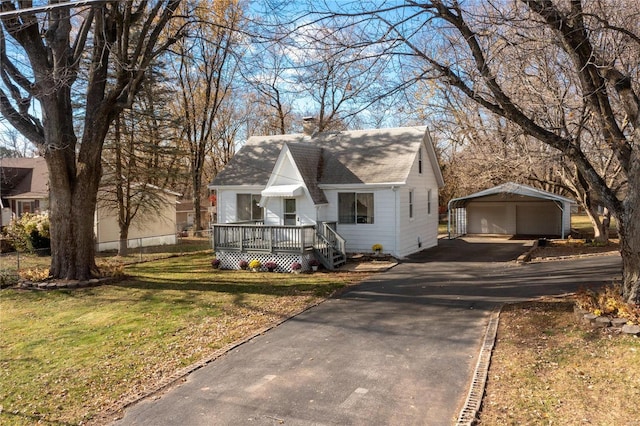 view of front facade with an outbuilding, a deck, and a front lawn