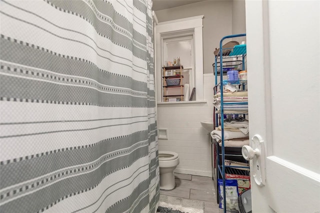 bathroom with tile walls and toilet