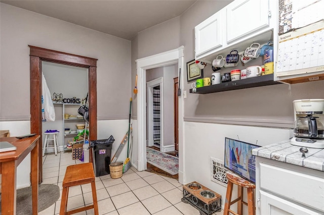 kitchen featuring tile countertops, white cabinets, and light tile patterned floors