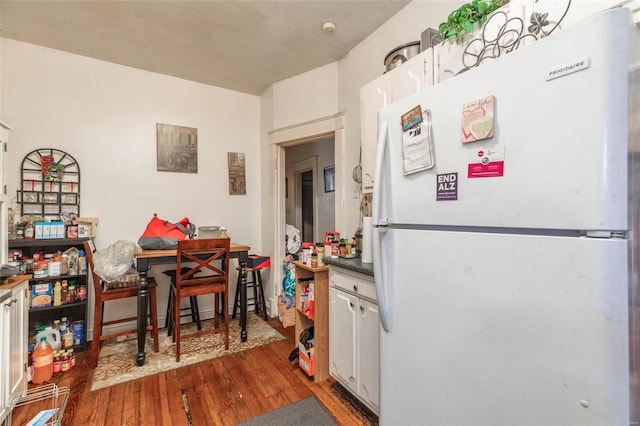 kitchen with hardwood / wood-style floors, white cabinets, and white refrigerator