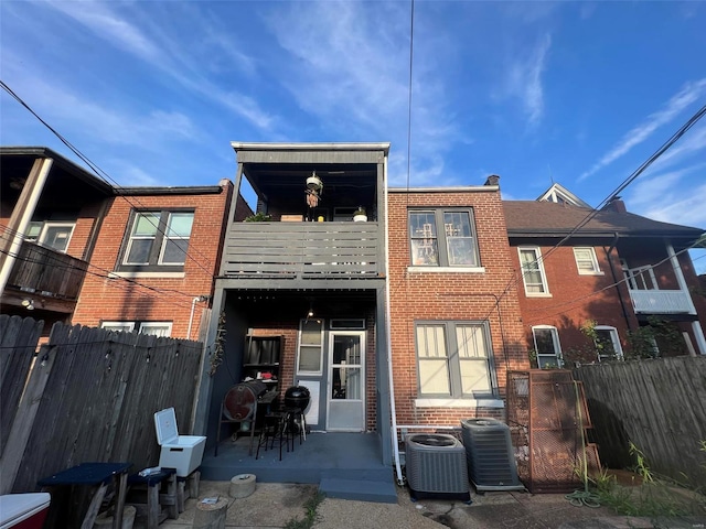 rear view of house with a patio, a balcony, and central air condition unit