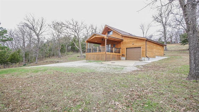 log cabin featuring a front lawn, covered porch, and a garage