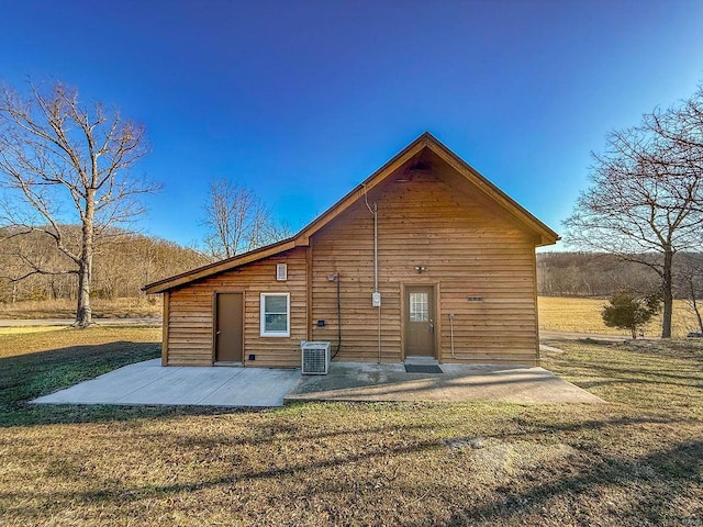 back of property with a patio area, central AC, and a yard