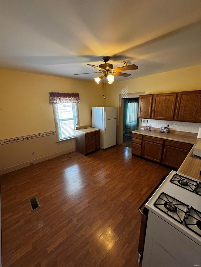 kitchen featuring dark hardwood / wood-style flooring, white appliances, and ceiling fan