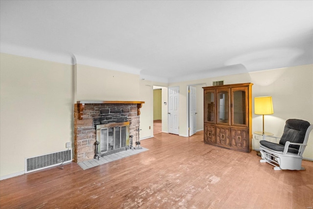 living room featuring hardwood / wood-style floors and a stone fireplace