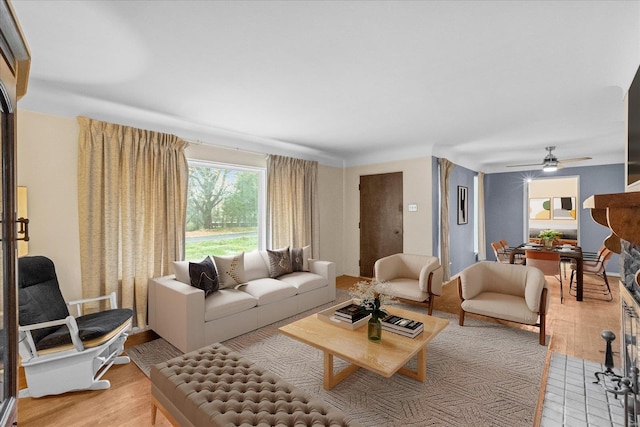 living room with ceiling fan and light hardwood / wood-style flooring