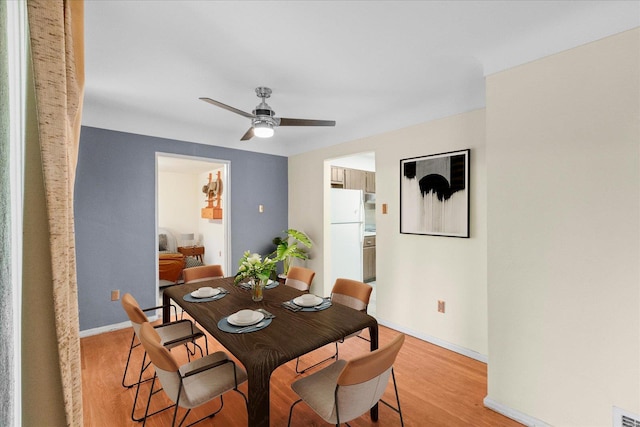 dining room with ceiling fan and light hardwood / wood-style floors