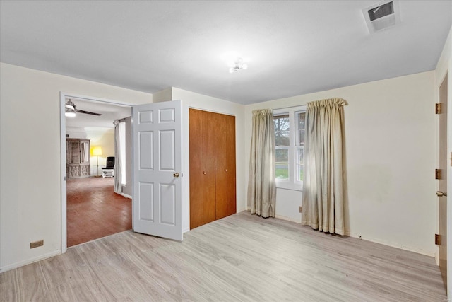 unfurnished bedroom featuring a closet and light hardwood / wood-style floors