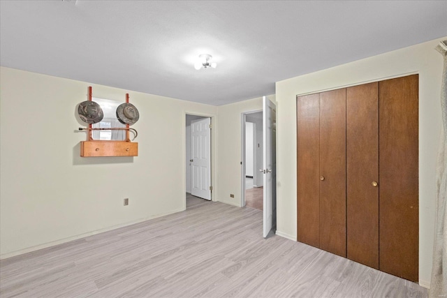 unfurnished bedroom with light hardwood / wood-style floors and a closet