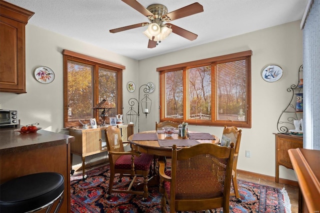 tiled dining space featuring ceiling fan and a textured ceiling