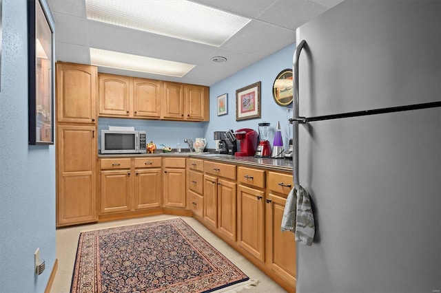 kitchen featuring stainless steel appliances and a drop ceiling