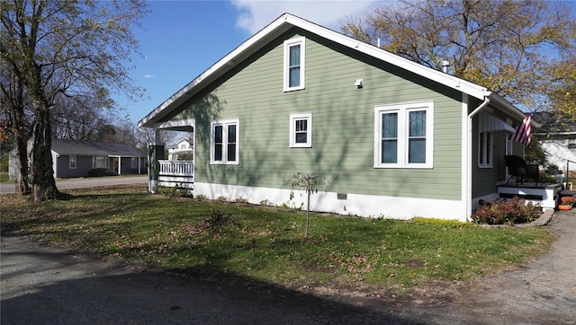 view of property exterior with a lawn and a porch