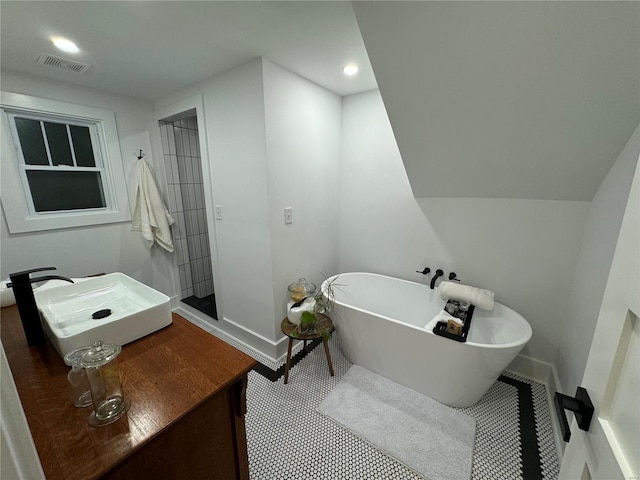 bathroom with a tub to relax in and sink