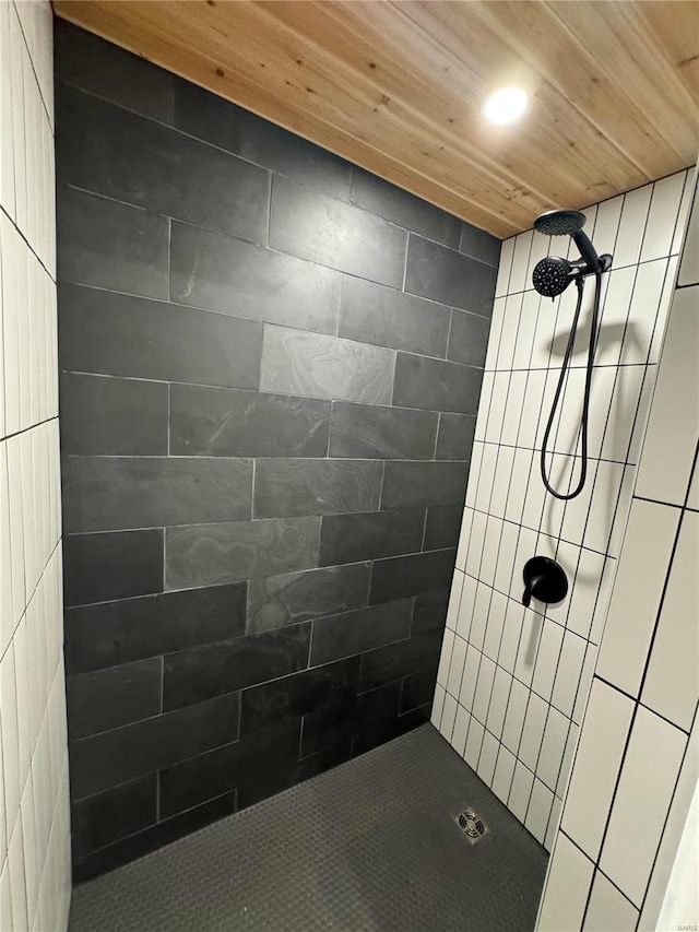 bathroom with a tile shower and wooden ceiling