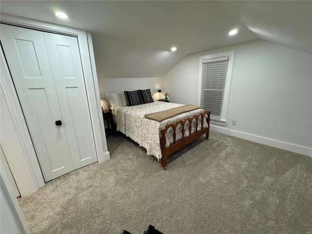 carpeted bedroom featuring vaulted ceiling and a closet