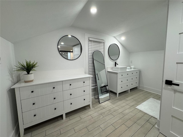 bedroom featuring sink and lofted ceiling