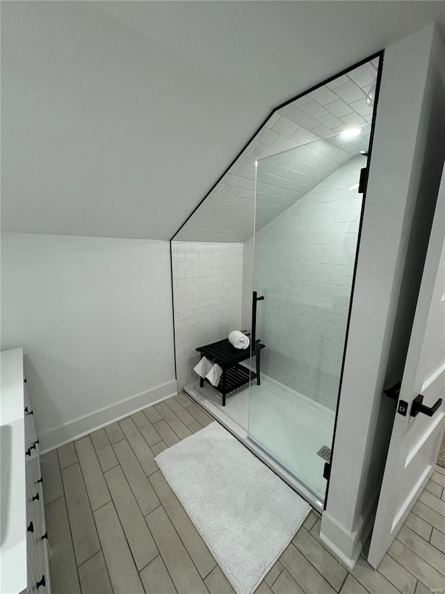 bathroom featuring tiled shower and vaulted ceiling