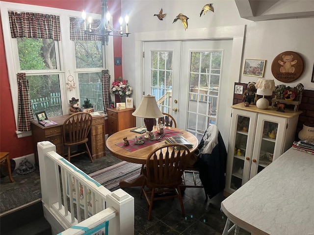 dining area featuring dark tile patterned floors, french doors, and an inviting chandelier