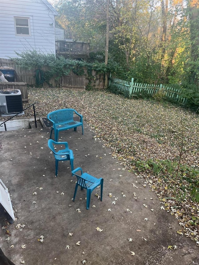 view of yard with central air condition unit and a patio