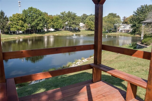 view of dock with a yard and a water view