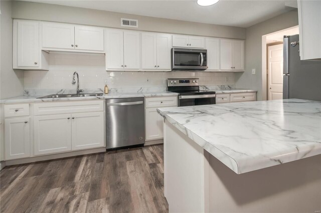 kitchen featuring tasteful backsplash, stainless steel appliances, sink, dark hardwood / wood-style floors, and white cabinetry