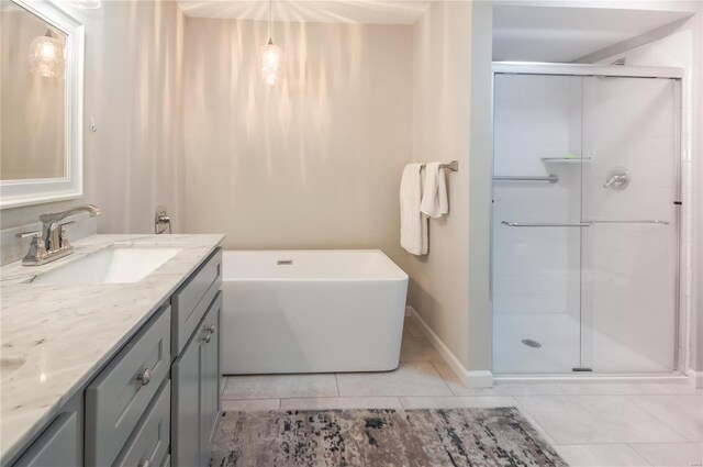 bathroom with tile patterned flooring, vanity, and shower with separate bathtub