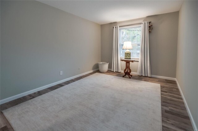 unfurnished room with dark wood-type flooring