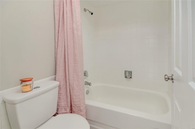 bathroom with shower / bath combo with shower curtain and toilet