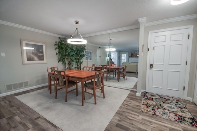 dining space featuring dark hardwood / wood-style floors and ornamental molding