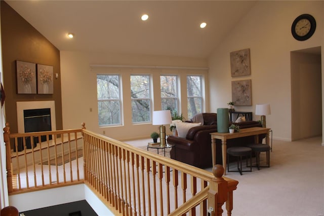 carpeted living room with high vaulted ceiling