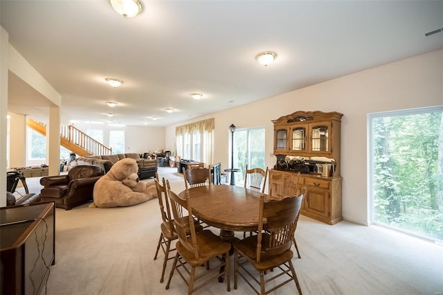 dining space with light colored carpet and a healthy amount of sunlight