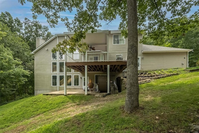 rear view of property with a patio area, a yard, and a wooden deck