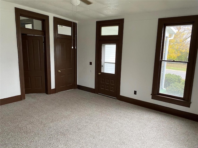 entrance foyer with light carpet and ceiling fan