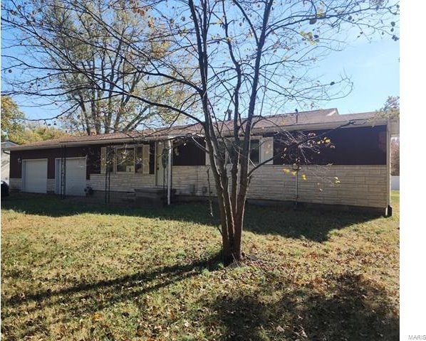 rear view of property featuring a yard