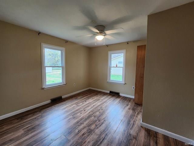 unfurnished room with dark hardwood / wood-style floors, plenty of natural light, and ceiling fan