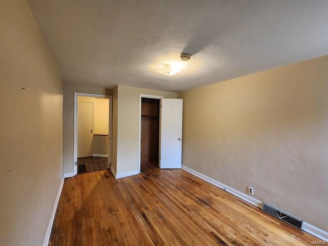 unfurnished bedroom with a closet and hardwood / wood-style floors