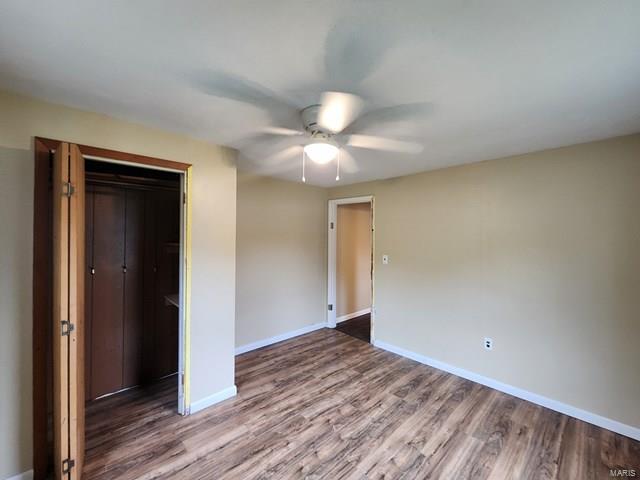 unfurnished bedroom with ceiling fan, wood-type flooring, and a closet