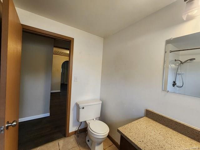 bathroom featuring a shower, tile patterned flooring, vanity, and toilet