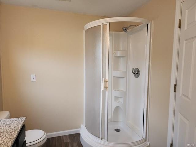 bathroom featuring hardwood / wood-style flooring, vanity, toilet, and an enclosed shower