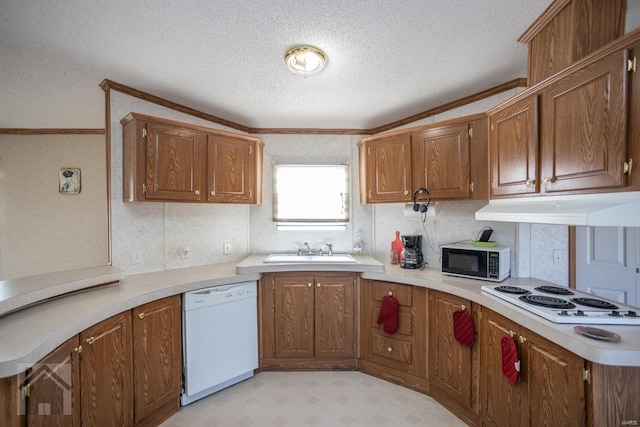 kitchen with a textured ceiling, white appliances, crown molding, and sink