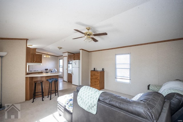 living room with ceiling fan, crown molding, light colored carpet, and vaulted ceiling