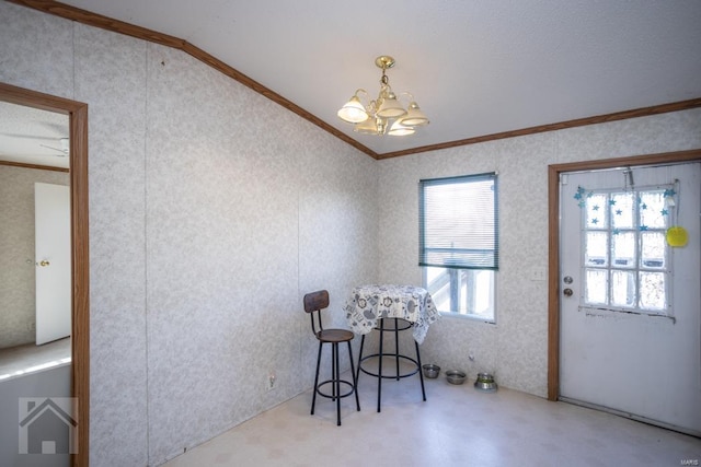 dining area with lofted ceiling, ornamental molding, and a chandelier